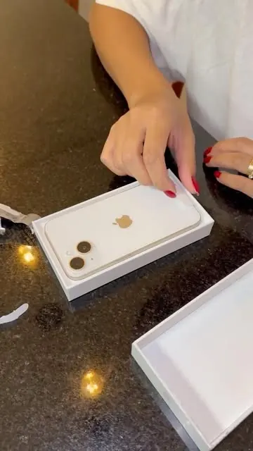iPhone 14 lacrado sendo aberto sobre a mesa